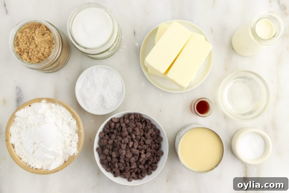 Millionaires Bars 4 A collection of ingredients laid out for making Millionaire’s Bars, including butter, sugars, flour, sweetened condensed milk, chocolate chips, and cream.