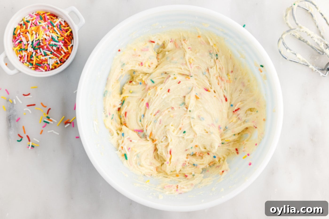 Close-up of the Funfetti cake mix cookie dough batter after sprinkles have been folded in, showing vibrant colors.