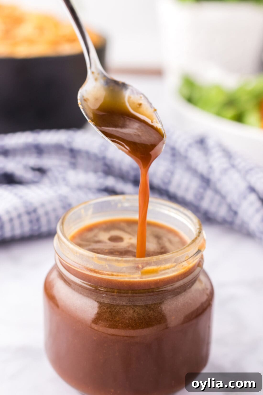 Homemade Teriyaki Sauce drizzled from a spoon into a jar