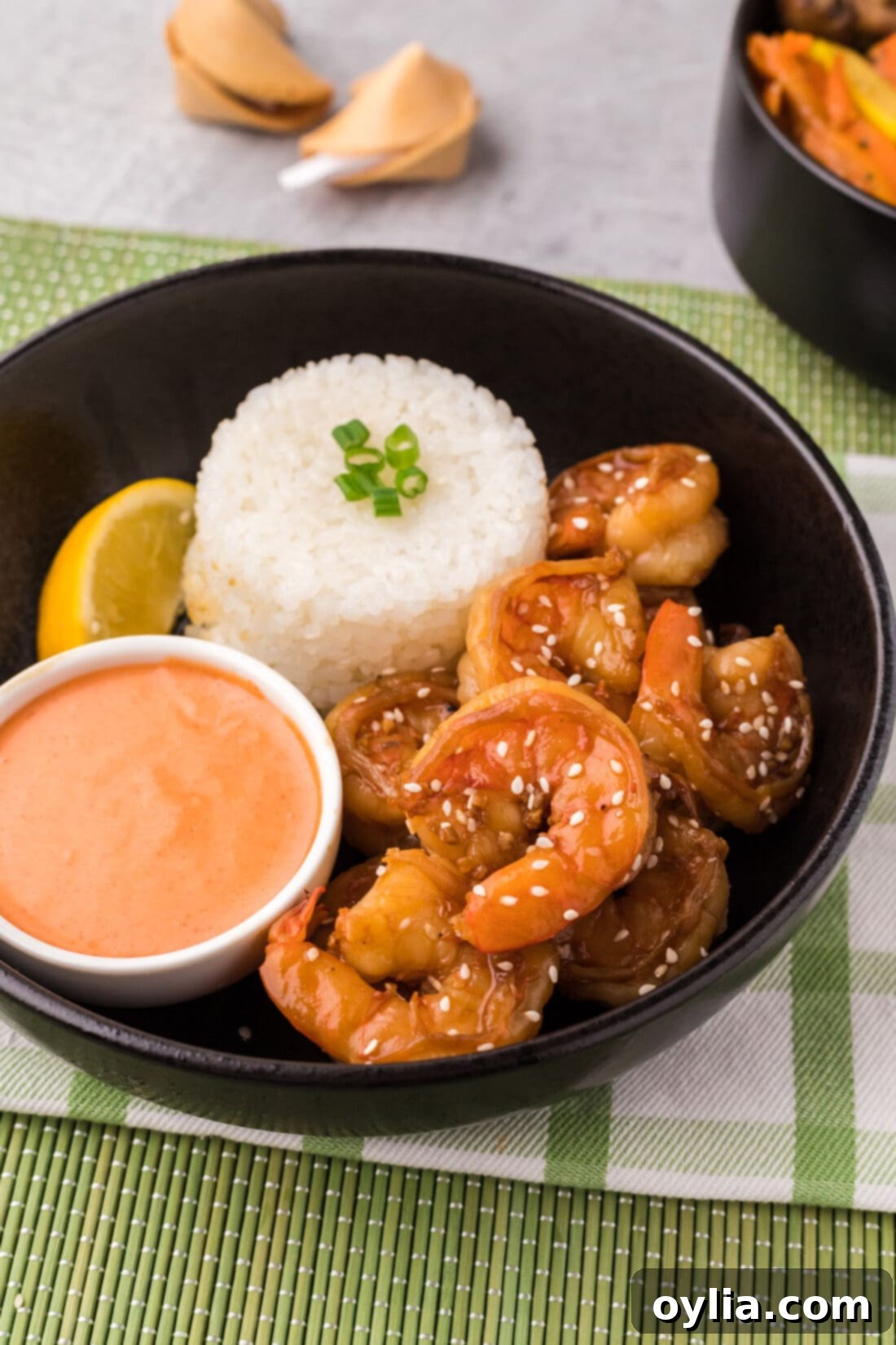 A bowl of vibrant Hibachi Shrimp served with fluffy white rice and a side of creamy Yum Yum Sauce, ready for a delicious meal.