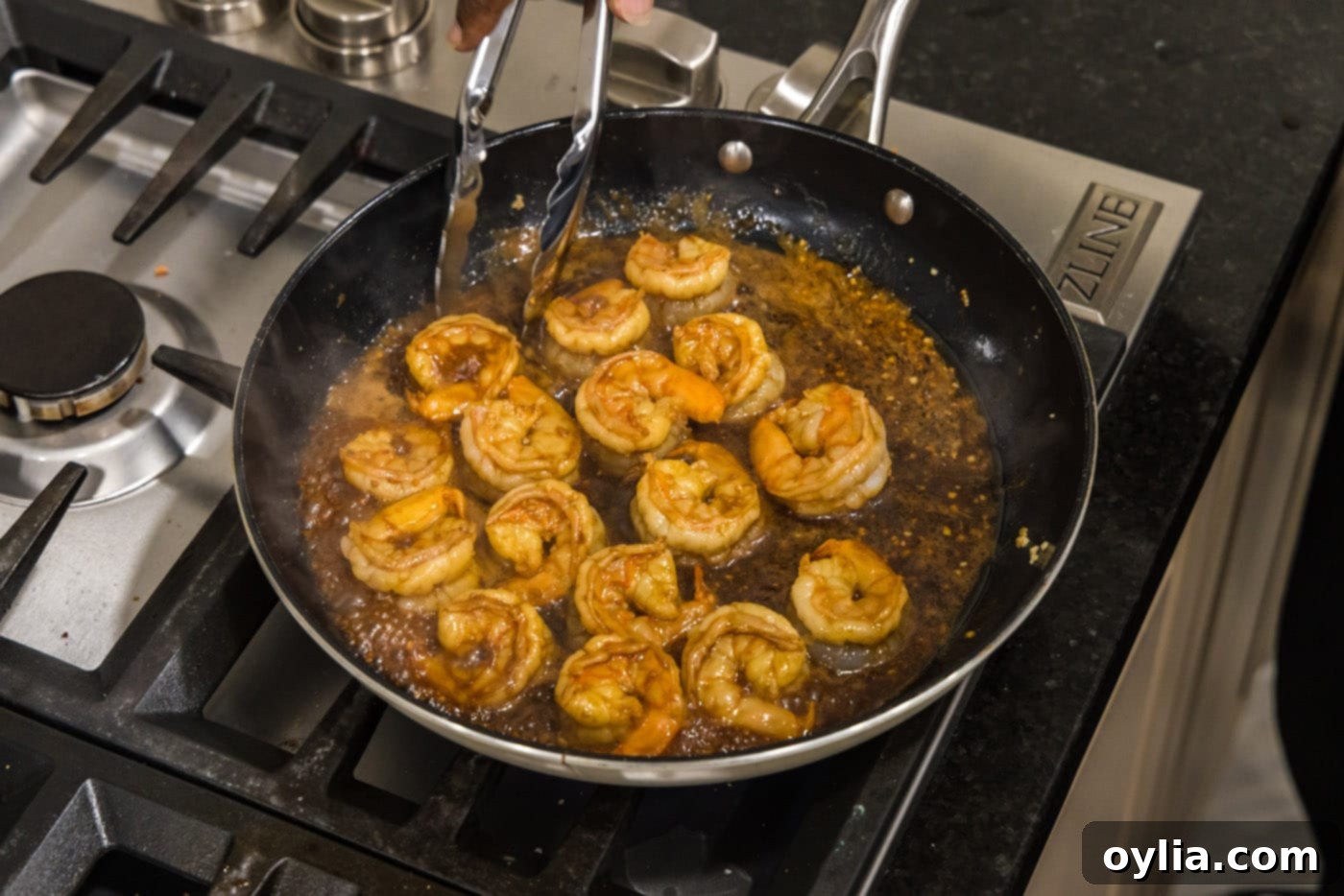 Perfectly pan-seared hibachi shrimp, glistening with sauce, resting in a skillet after cooking.