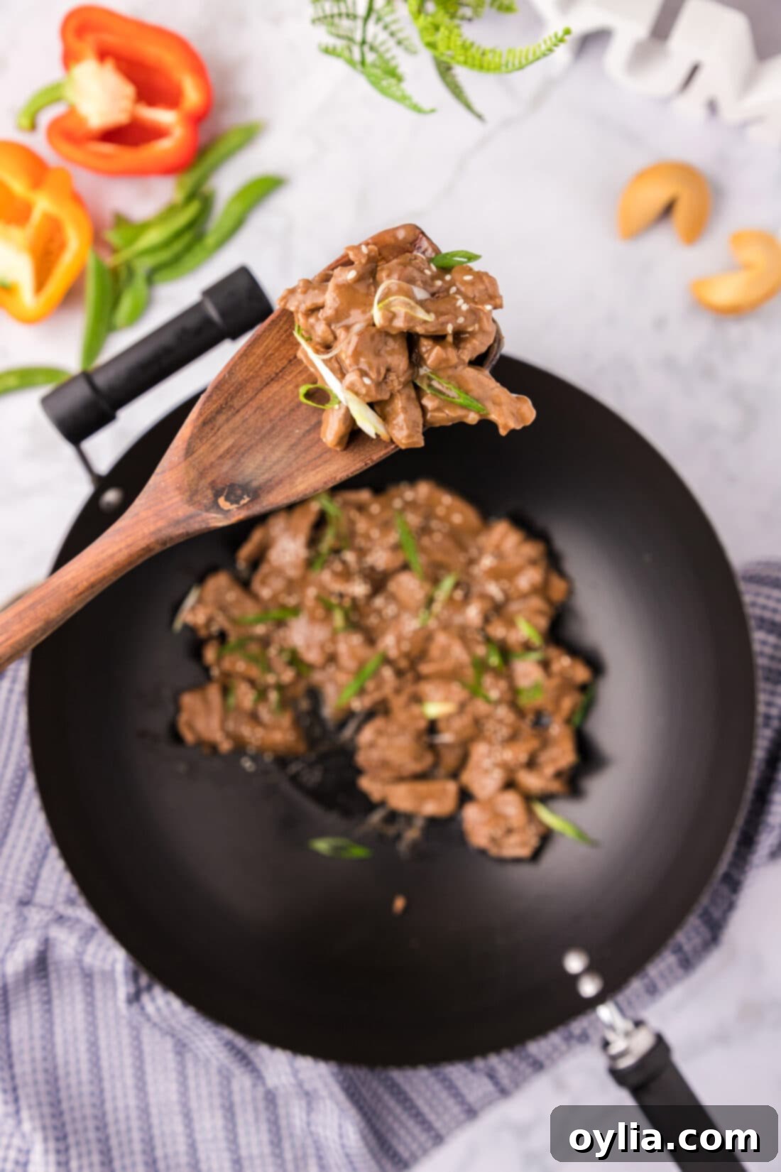 Teriyaki Glazed Beef 2 Spoonful of Beef Teriyaki held above a skillet of Beef Teriyaki, showcasing tender beef and rich sauce