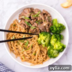 Teriyaki Glazed Beef 11 Beef Teriyaki on a plate served with teriyaki noodles and broccoli, garnished with sesame seeds