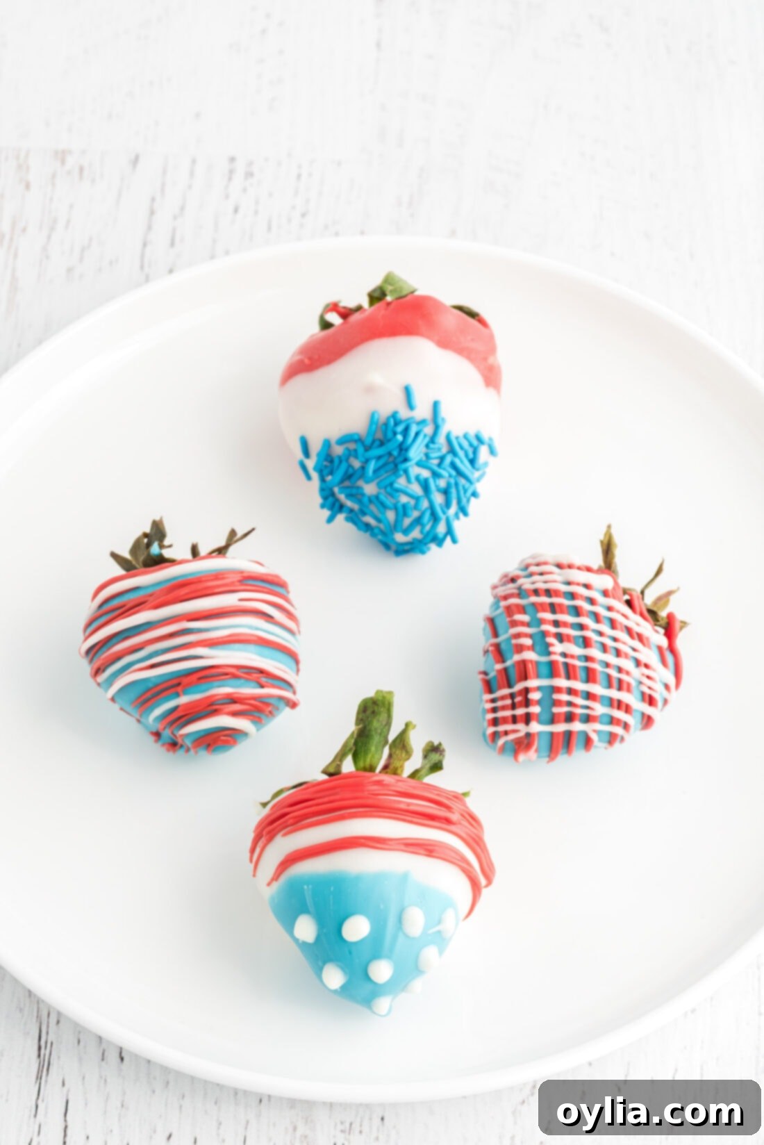 Patriotic Chocolate Covered Strawberries on a plate, featuring red, white, and blue designs.