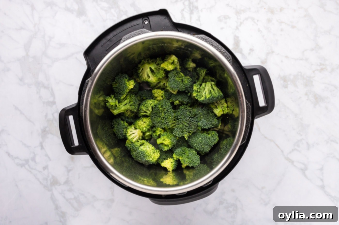 Broccoli florets and water inside an Instant Pot, ready for cooking.