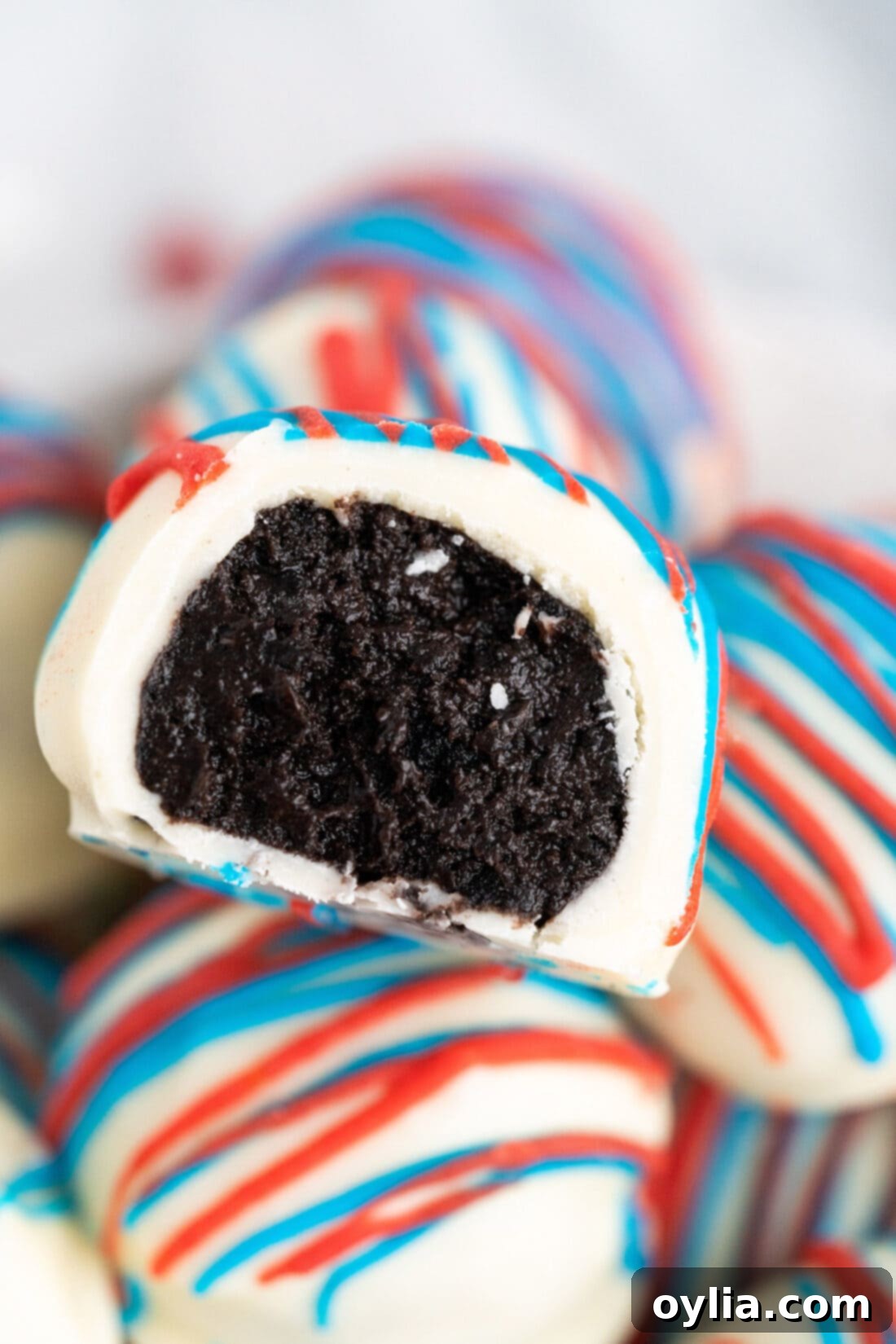 Close up photo of a Red White and Blue Oreo Truffle with a bite taken out