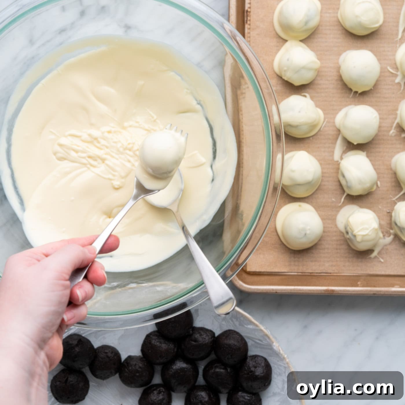 dipping oreo truffles into melted chocolate