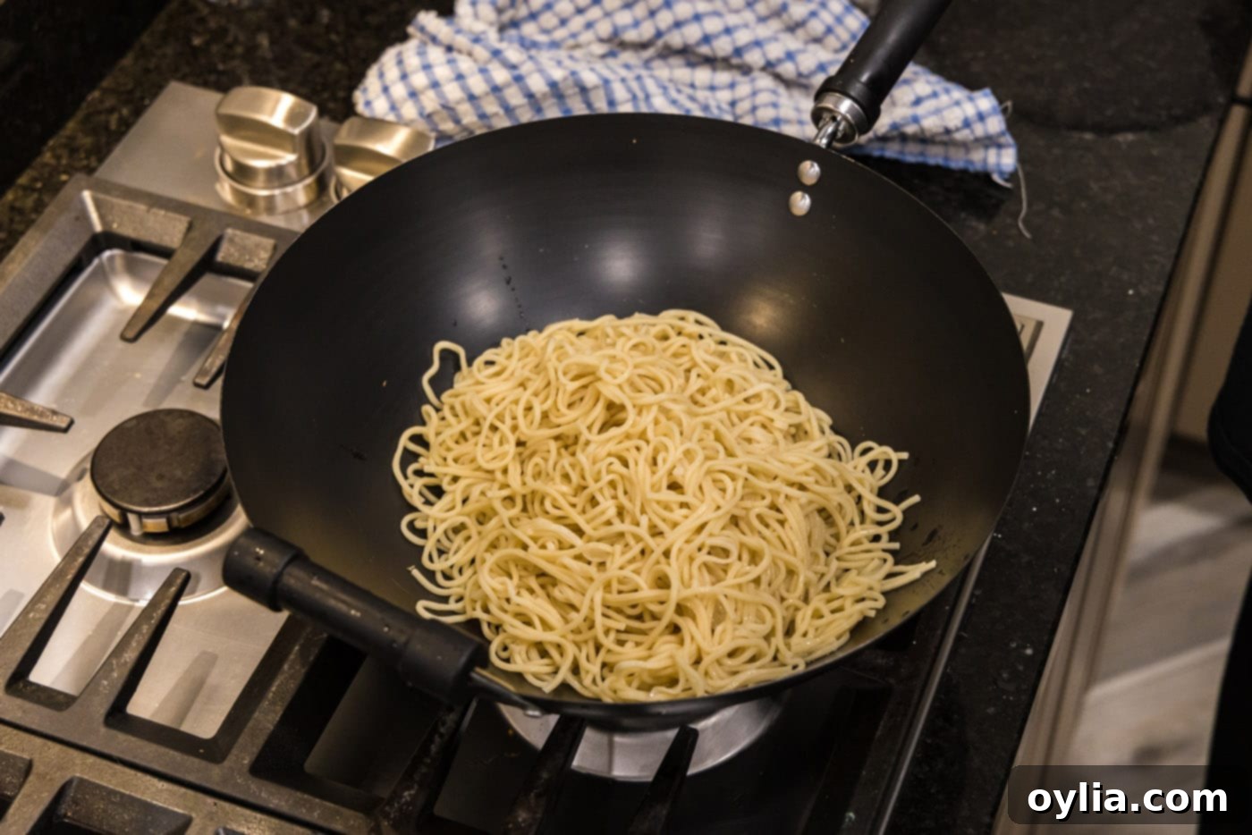 cooked lo mein noodles in a wok, ready for sauce