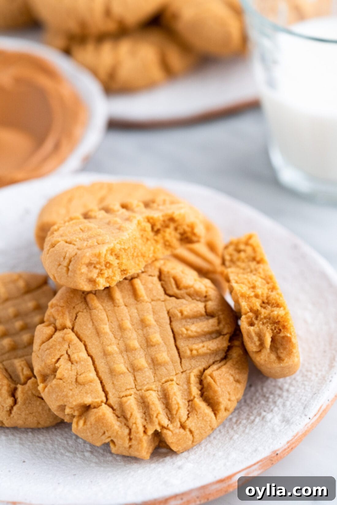 Simple Peanut Butter Cake Mix Treats 2 Soft and chewy peanut butter cake mix cookies on a plate, with one broken in half to show its tender interior.