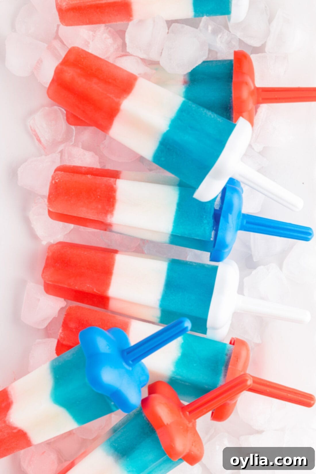 Stars and Stripes Rocket Pops 3 Patriotic Bomb Pops on a serving tray with ice, showcasing the distinct red, white, and blue layers for a refreshing summer treat.