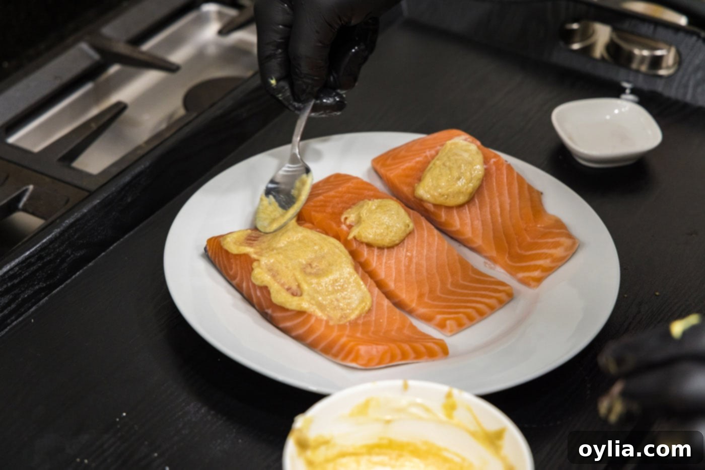 spoon spreading brown sugar glaze over salmon