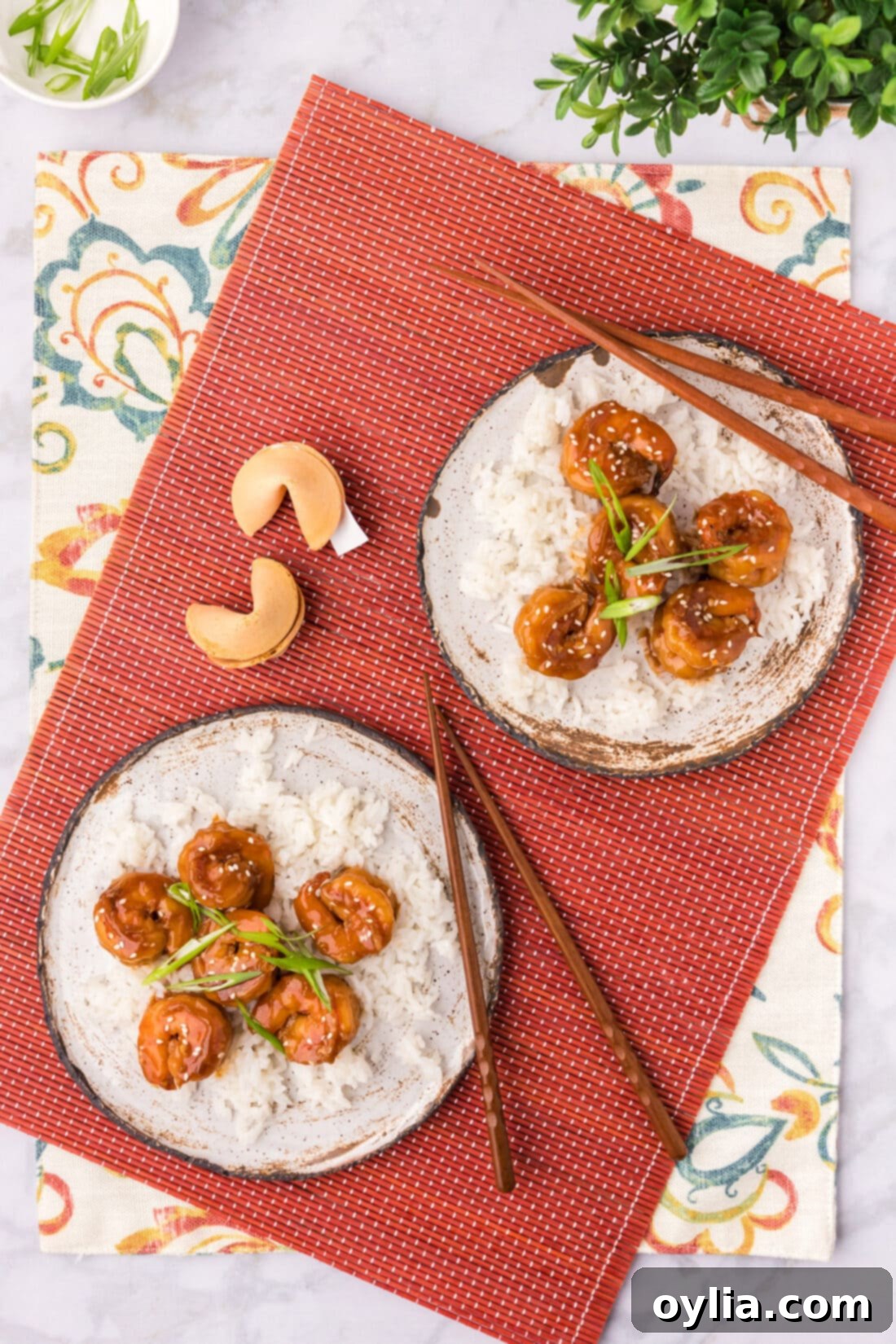 Two plates of Hunan Shrimp with chopsticks and fortune cookies