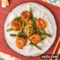 Plate of Hunan Shrimp served over rice and garlic green beans