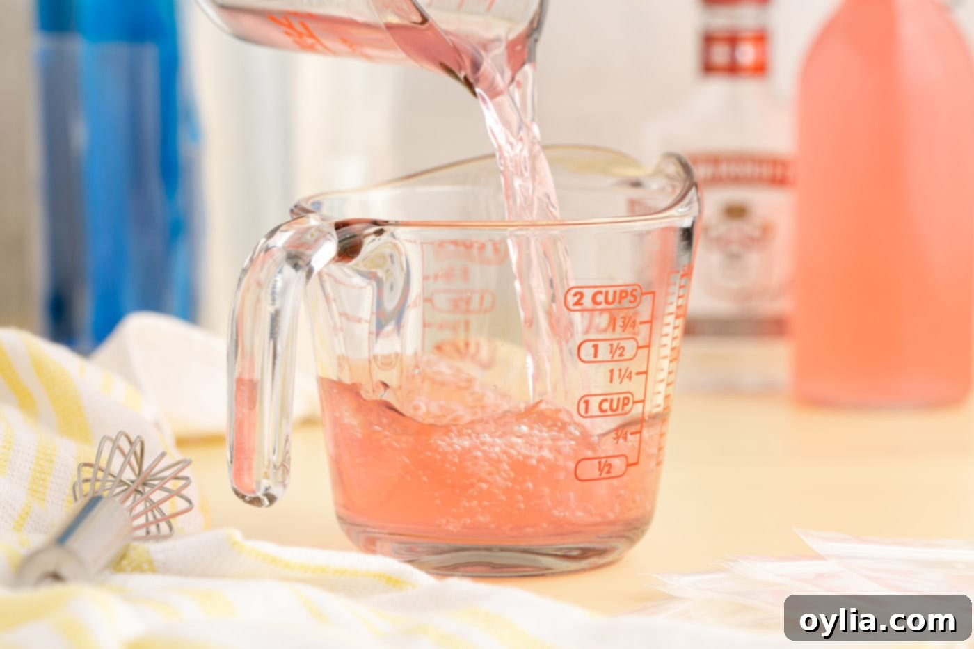 pouring juice into a measuring cup with vodka