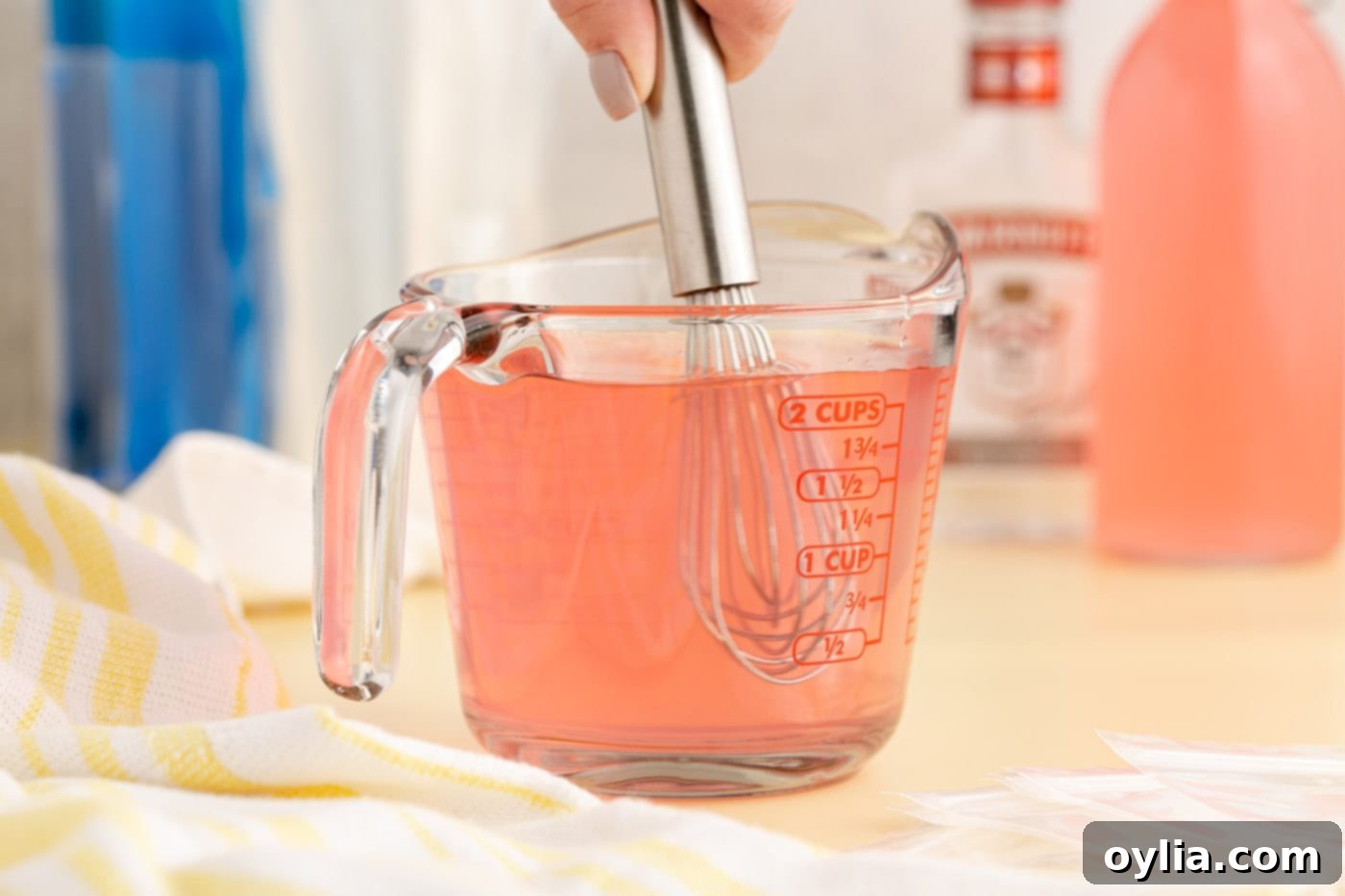 whisking juice and vodka in a cup
