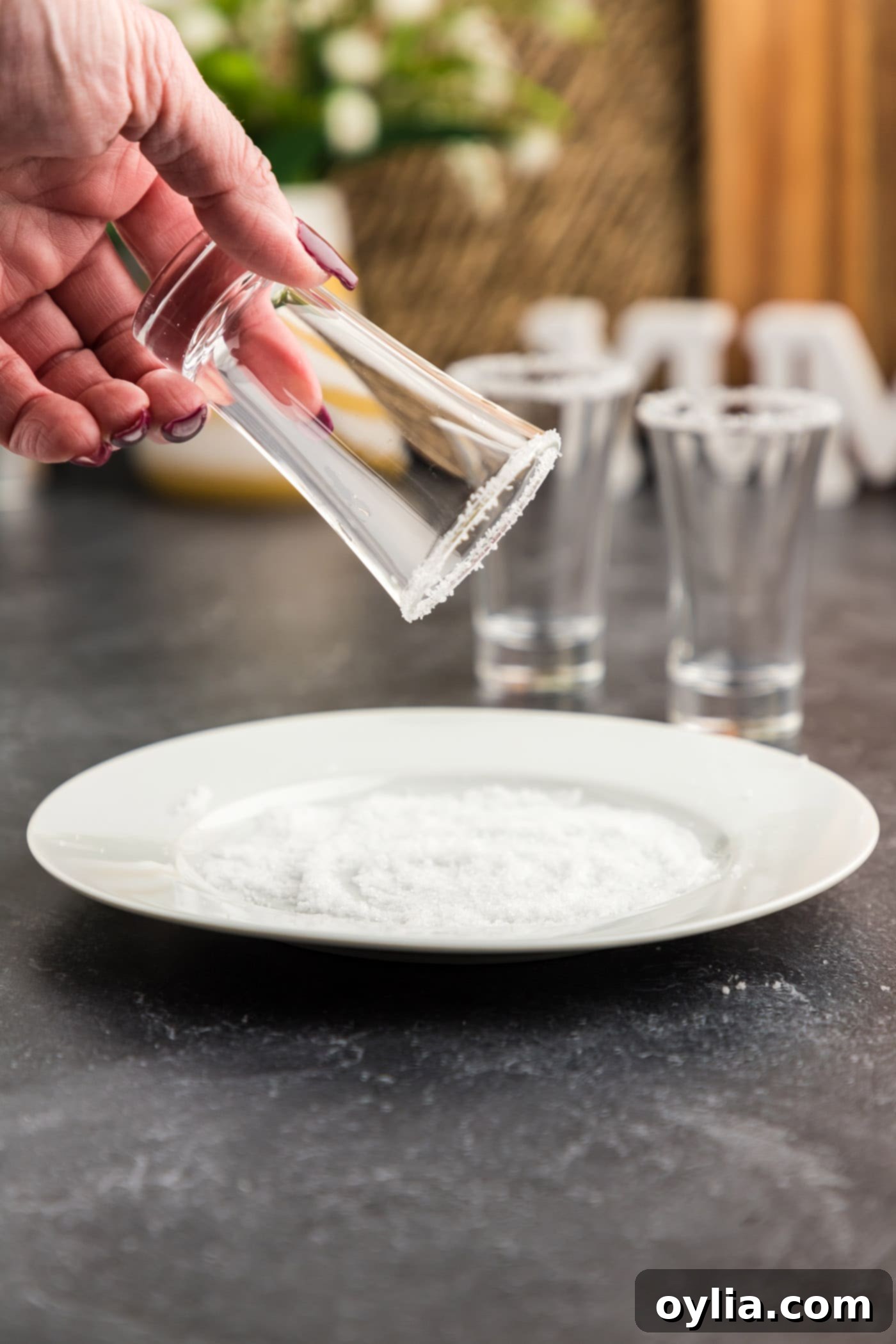 dipping wet shot glass rim into salt