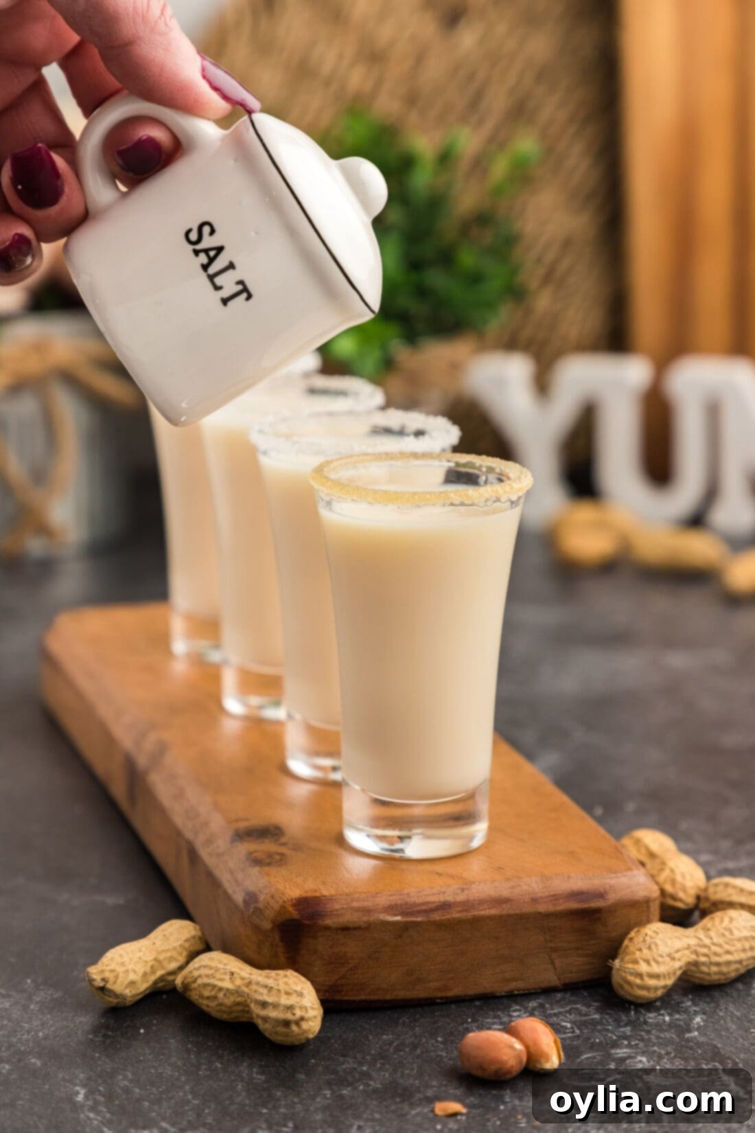 Salt shaker held above a row of Salted Nut Roll Shots