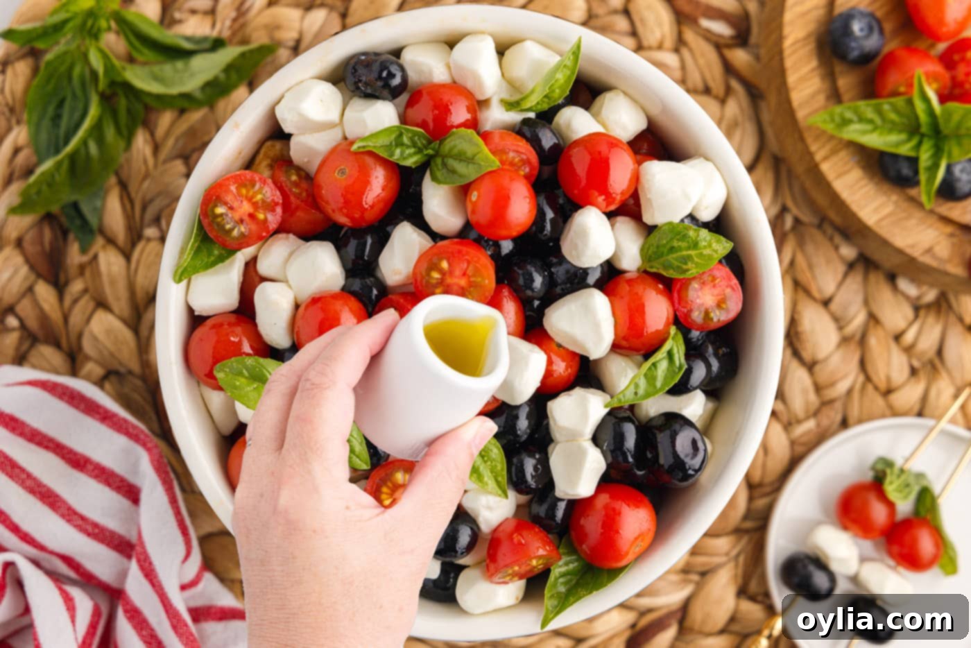 drizzling balsamic glaze over patriotic caprese salad
