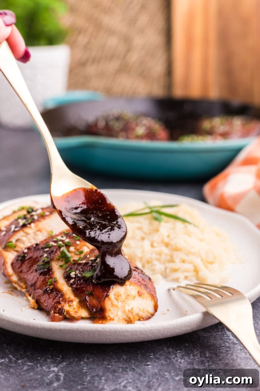 Spoonful of sauce bring drizzled over a Honey Garlic Chicken Breast