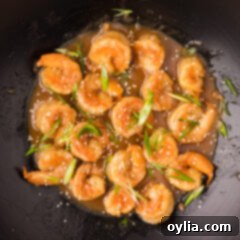 Close up photo of Teriyaki Shrimp in a wok, perfectly cooked and coated in sauce.