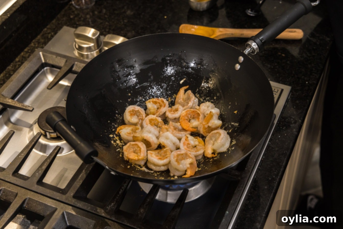 Close-up of shrimp being stir-fried in a skillet, showing the cooking process.