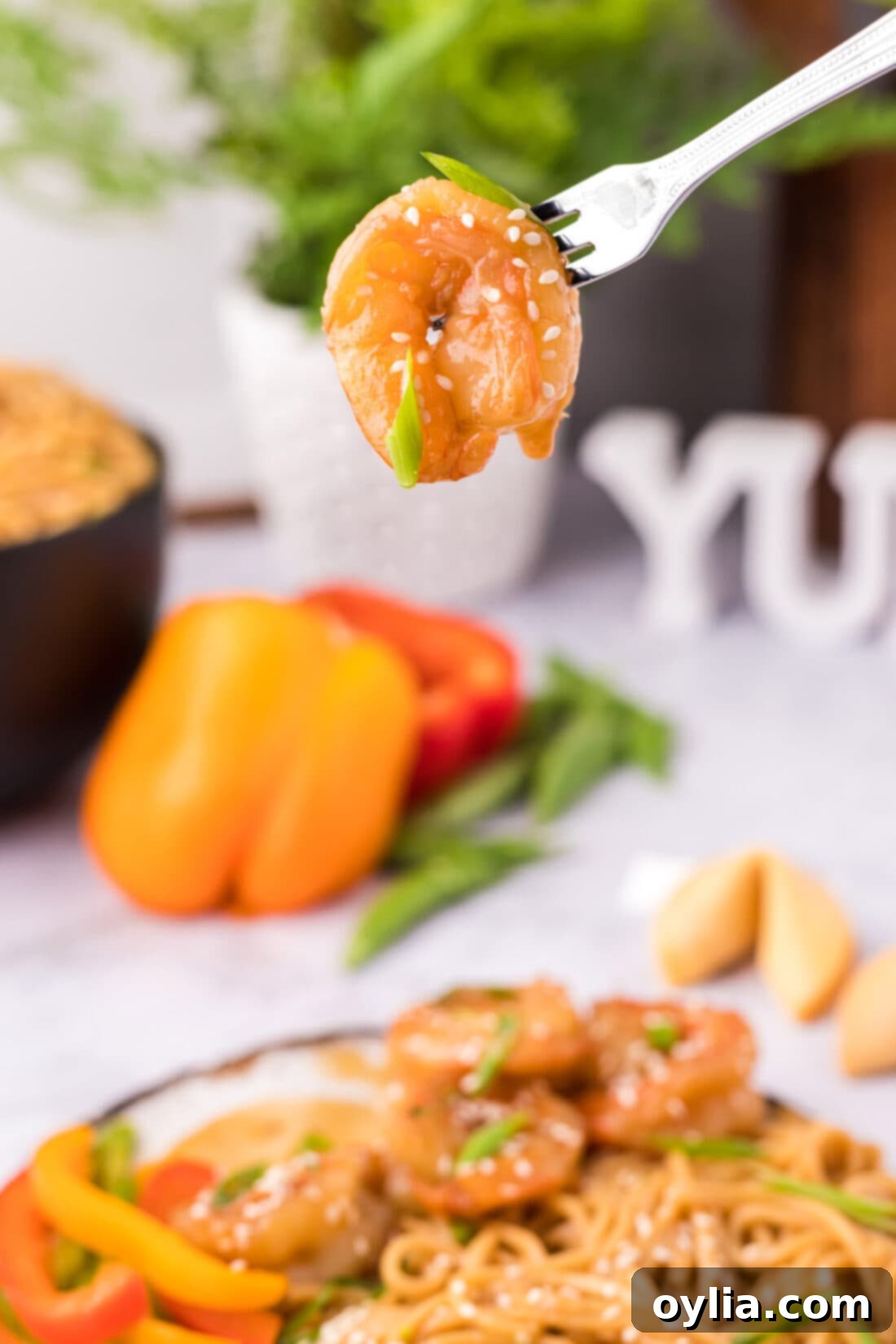 Close-up of a single piece of perfectly cooked Teriyaki Shrimp on a fork, glistening with sauce.
