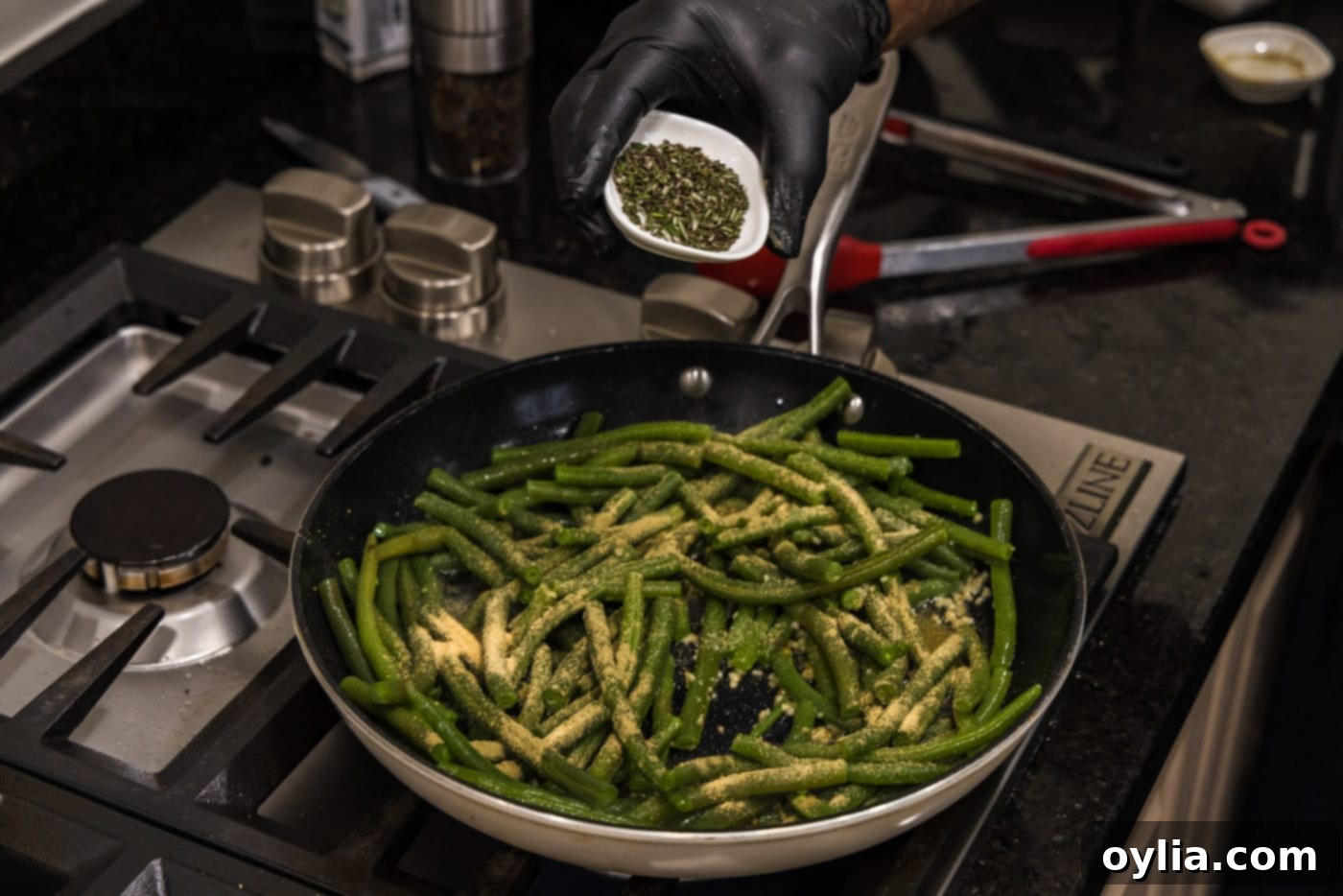 adding rosemary to skillet with green beans