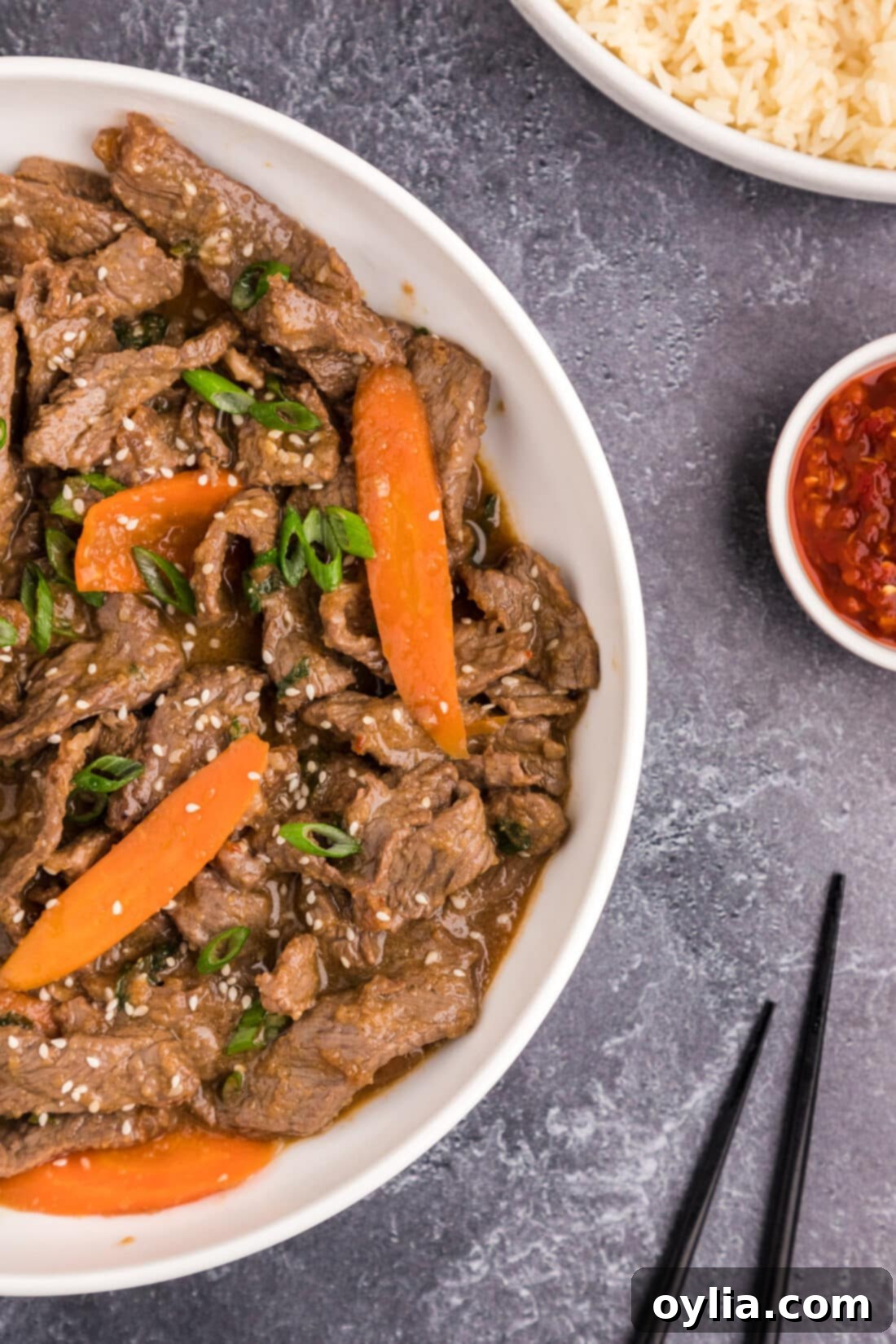 Sweet and Savory Korean BBQ Beef 11 A close-up of a serving of Beef Bulgogi in a white bowl, garnished with sesame seeds and green onions, showcasing its appetizing appearance.