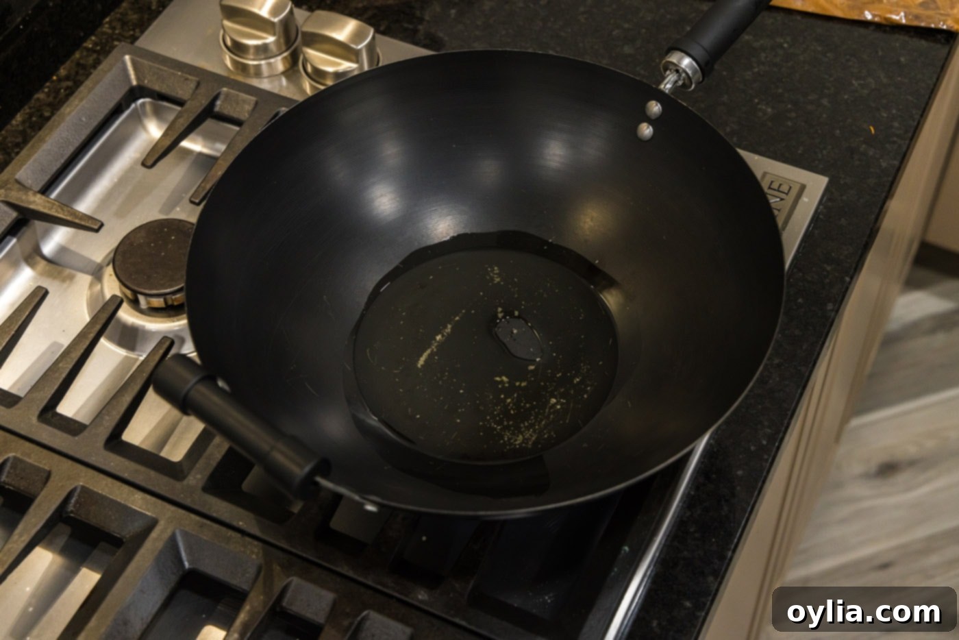Olive oil heating and shimmering in a wok, ready for cooking.