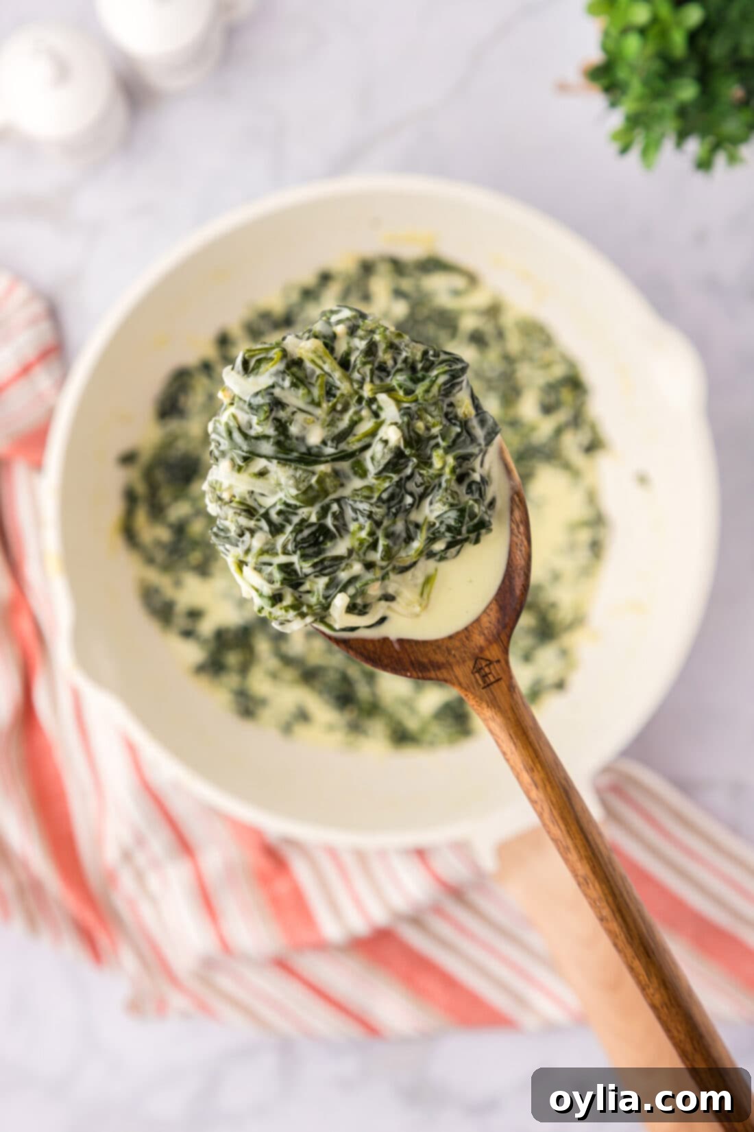 Decadent Creamed Spinach 2 Spoonful of Creamed Spinach held above a skillet of Creamed Spinach