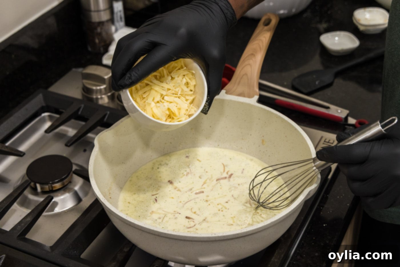 Decadent Creamed Spinach 7 adding parmesan cheese to skillet with heavy cream