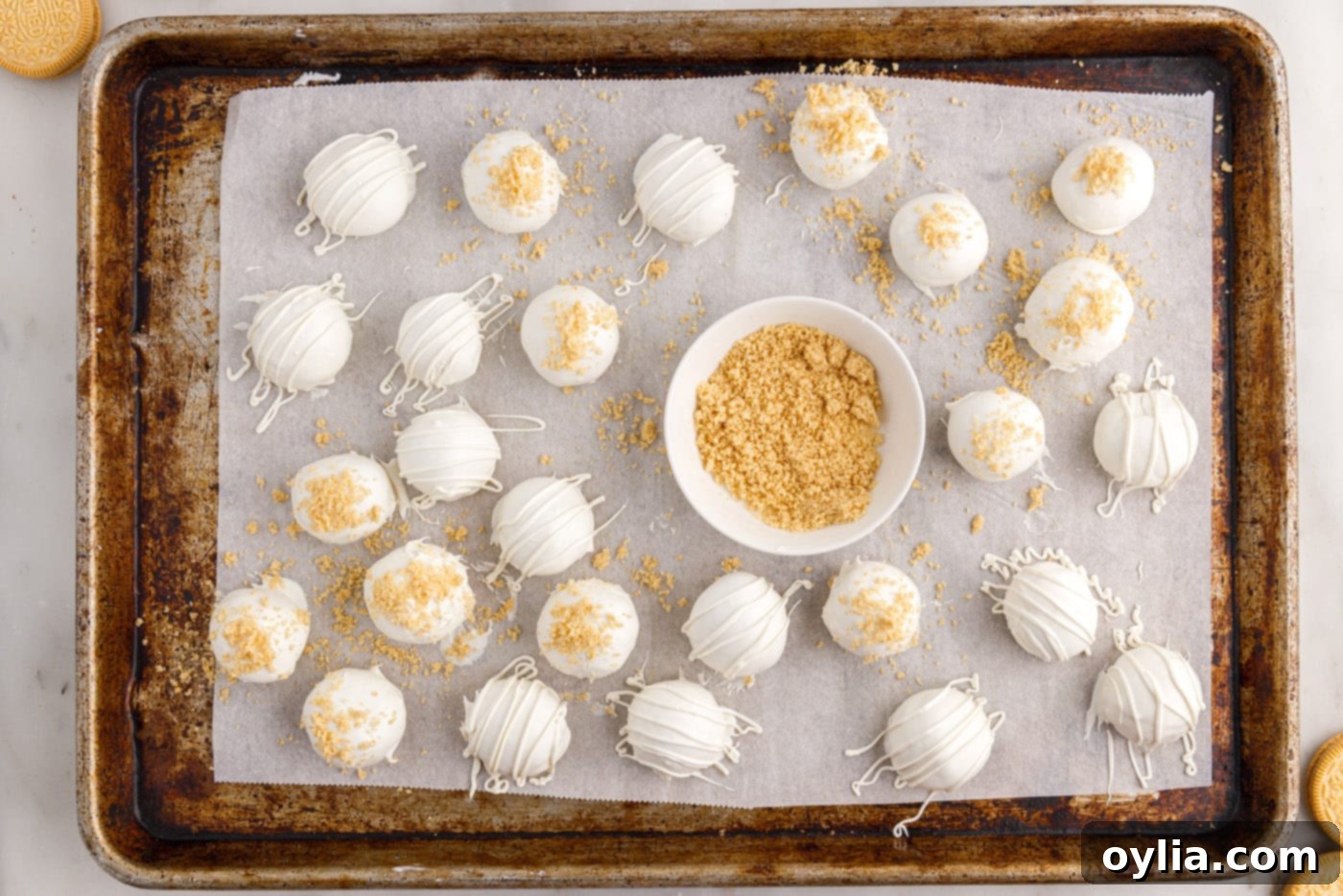 Golden Oreo cookie crumbs being sprinkled on top of a freshly dipped truffle