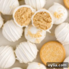 Golden Oreo Truffles 18 Close up photo of a Golden Oreo Truffle cut in half resting on top of more Golden Oreo Truffles, showing the creamy golden filling