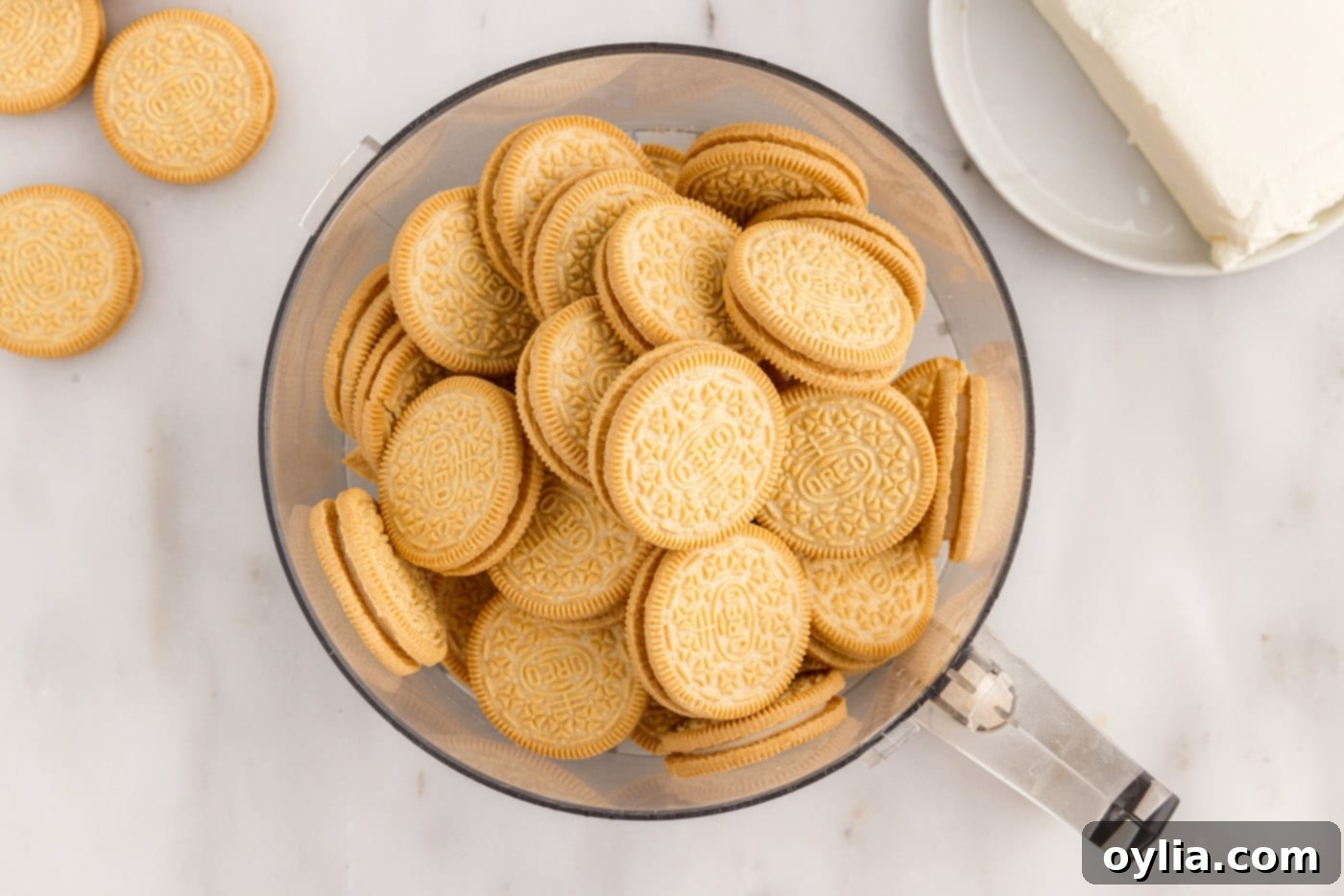 Golden Oreo cookies being crushed into fine crumbs in a food processor