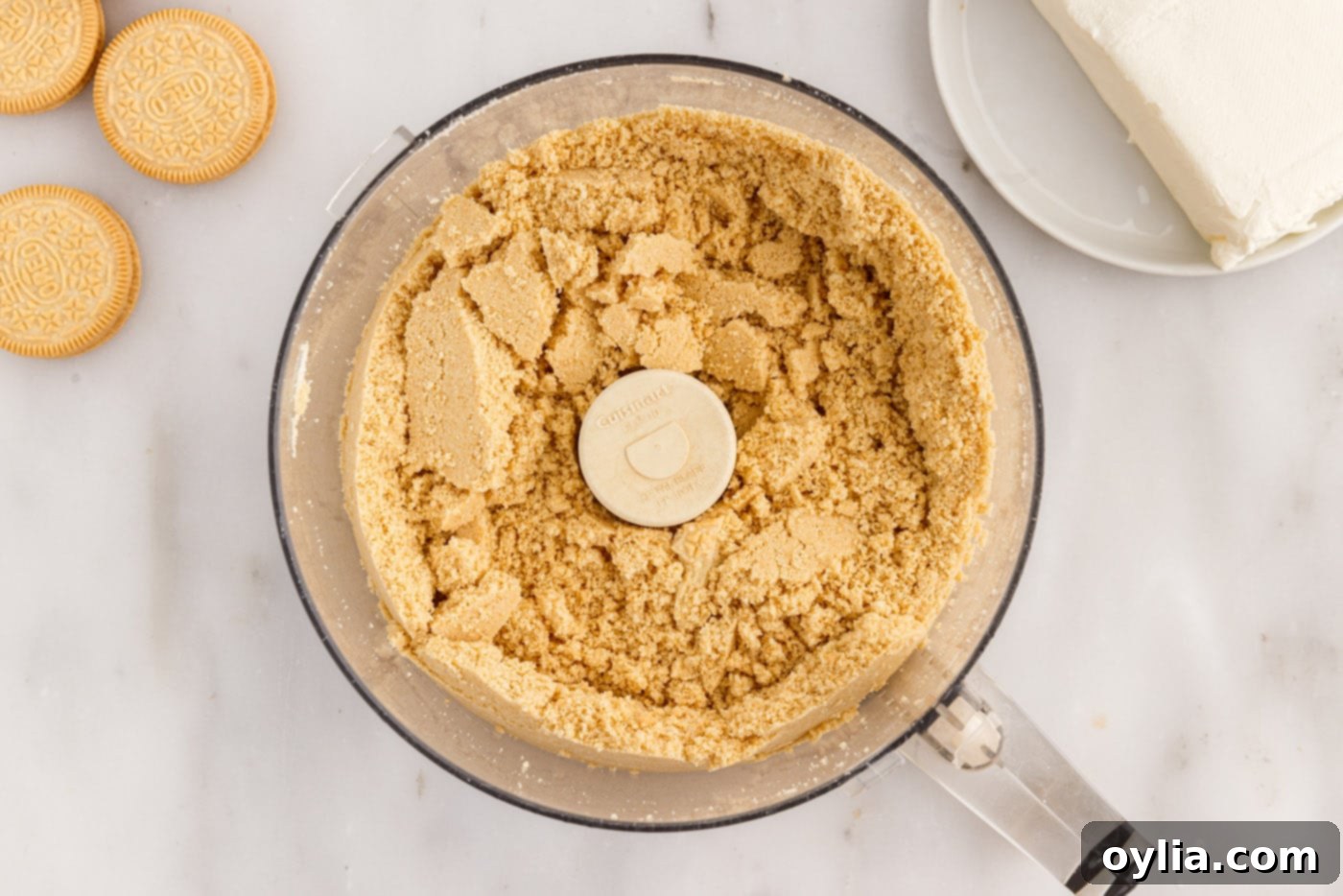 Finely crushed Golden Oreo cookie crumbs in a food processor bowl