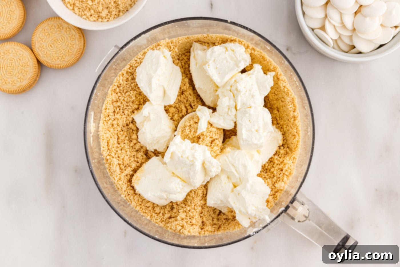 Softened cream cheese added to Golden Oreo crumbs in a food processor