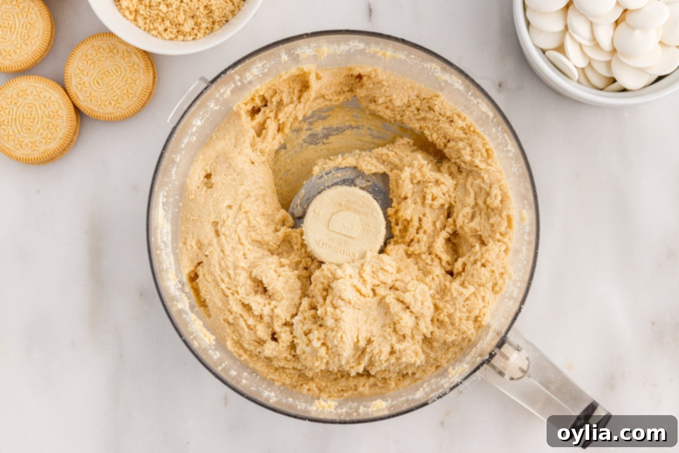 Creamy Golden Oreo and cream cheese mixture forming a dough in the food processor