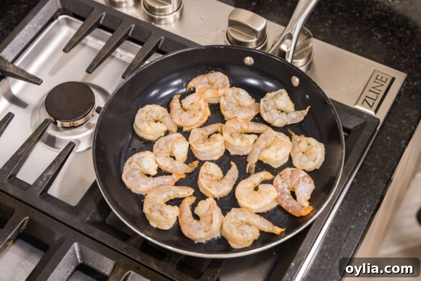 Shrimp sizzling and cooking in a hot skillet until golden and opaque