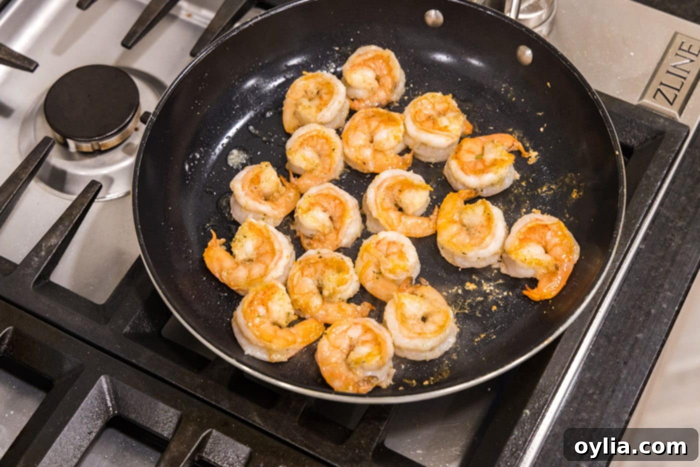 Perfectly golden sauteed shrimp in a skillet, ready to be removed