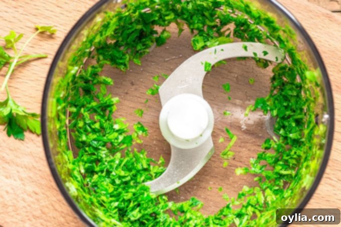 An overhead photo of cilantro chopped in a food processor. 