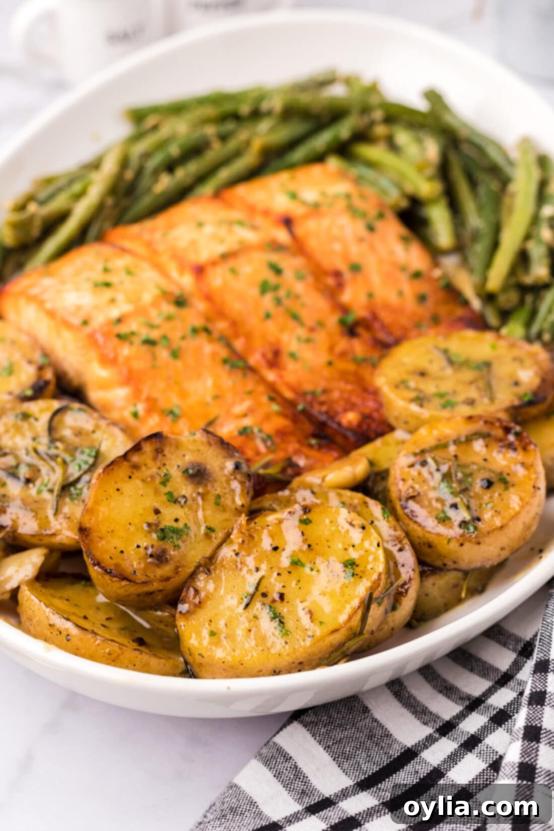 Melting Potatoes on a platter with garlic green beans and brown sugar salmon