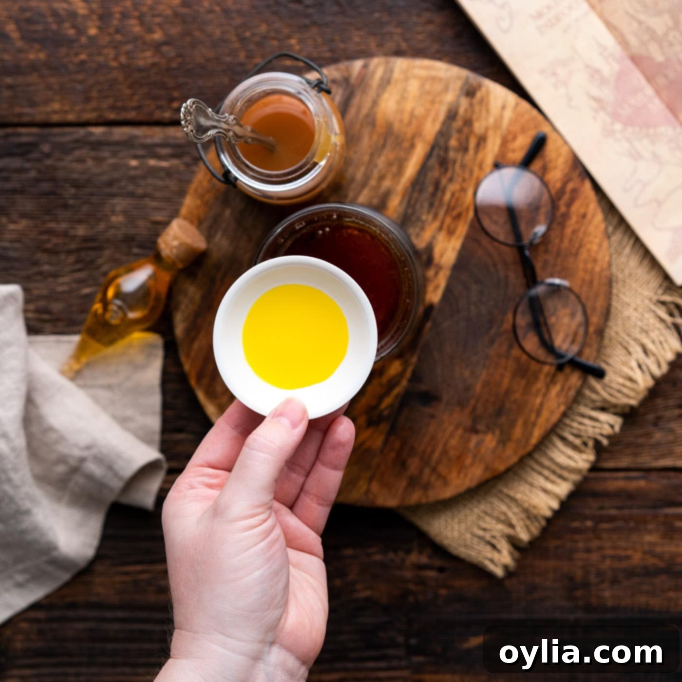A small bottle of butter extract being added to the Butterbeer mixture for an enhanced buttery flavor.