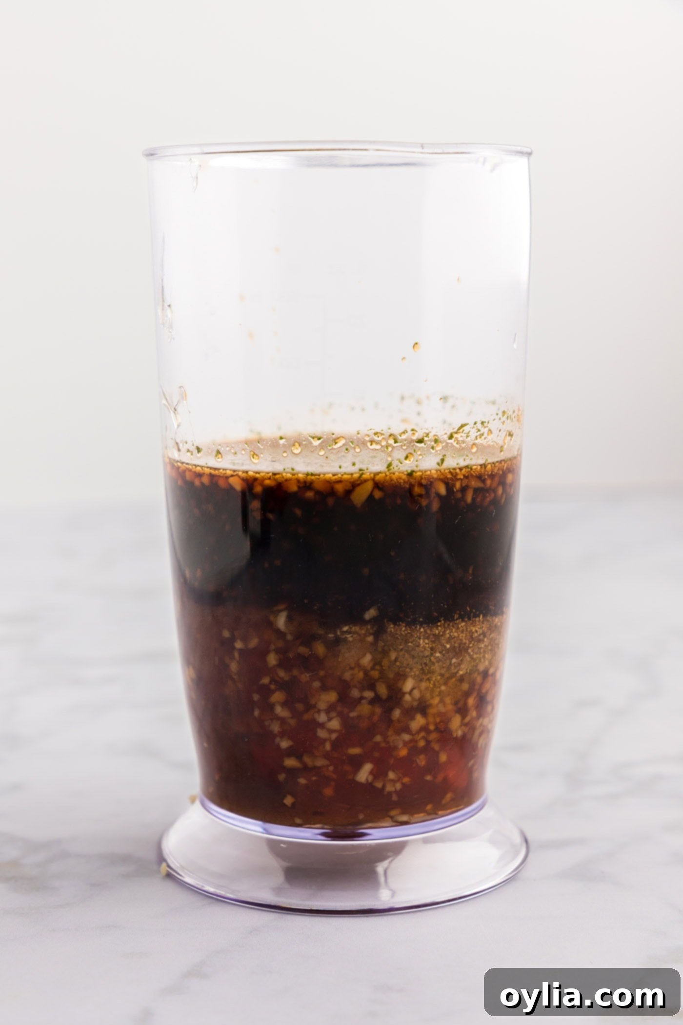 Soy sauce, vinegar, garlic, brown sugar, and honey in an immersion blender cup before blending.