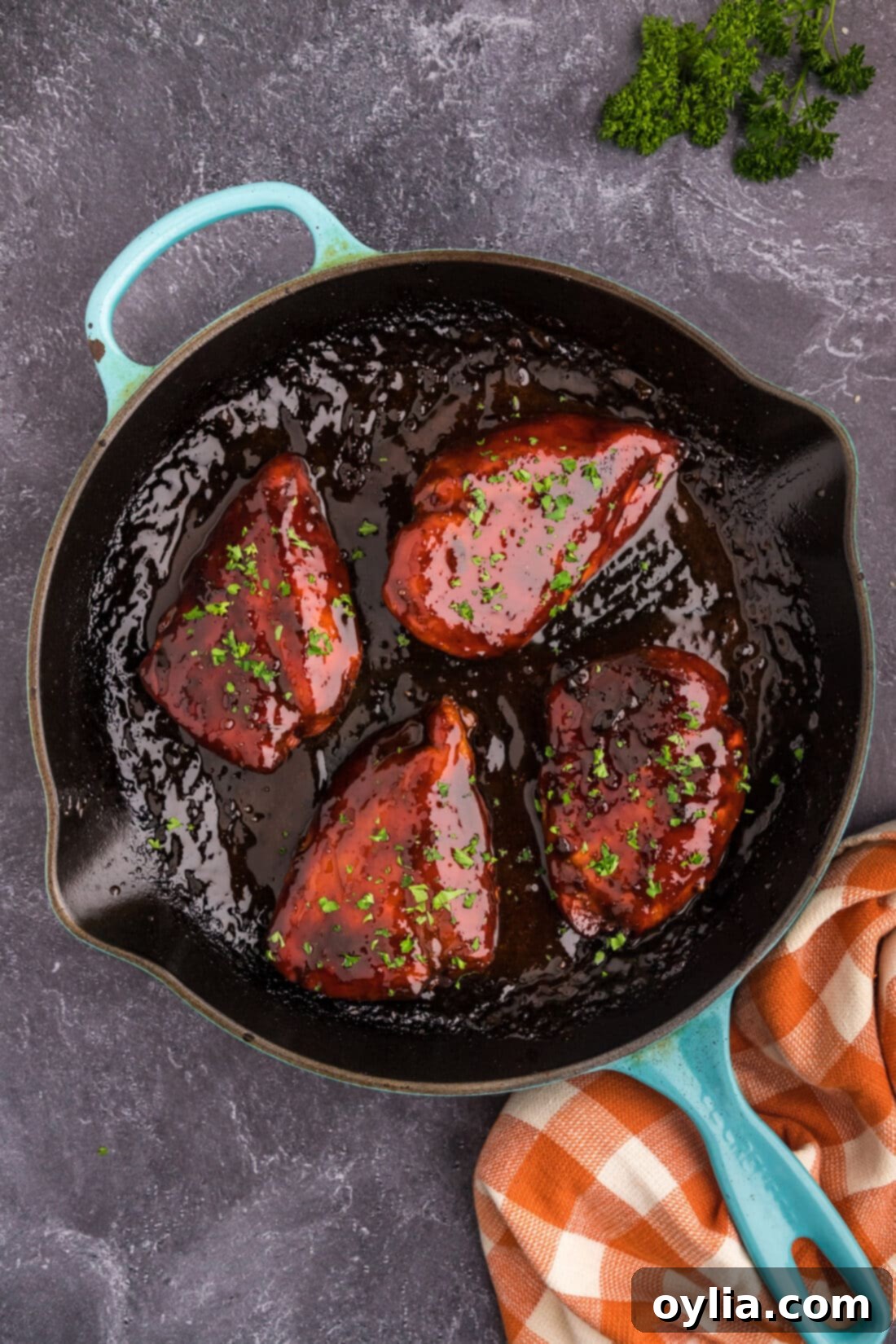 Cooked honey garlic chicken breasts simmering in a skillet with the thickened glaze.