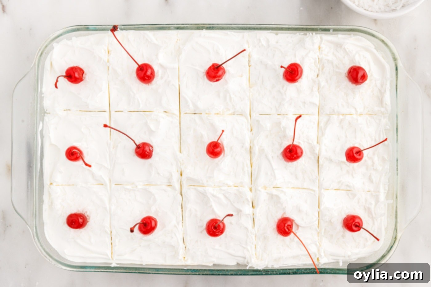 millionaire's cake sliced with maraschino cherries and shredded coconut