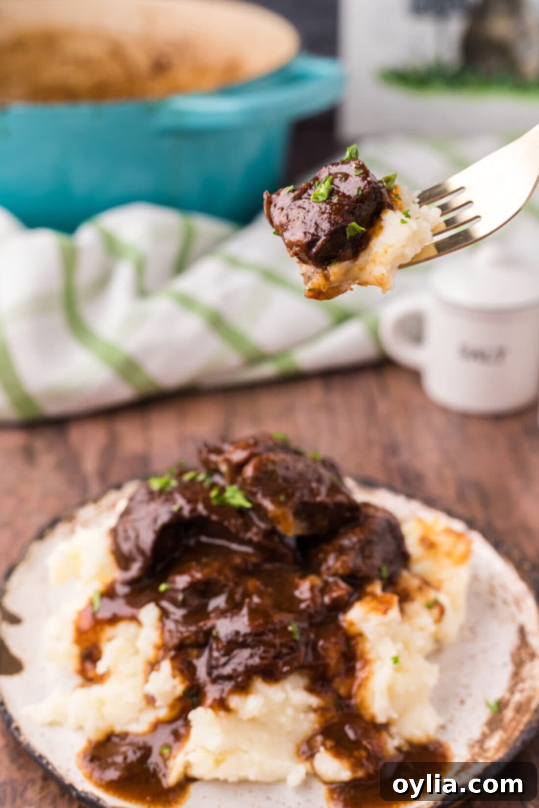 Piece of Beef Tips and Gravy on a fork with mashed potatoes, showcasing the tender beef and rich gravy.