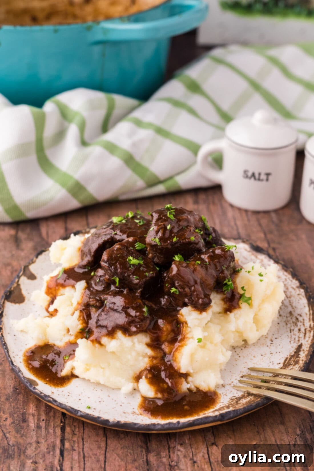 Plate of Beef Tips and Gravy served over creamy mashed potatoes, ready to be enjoyed.