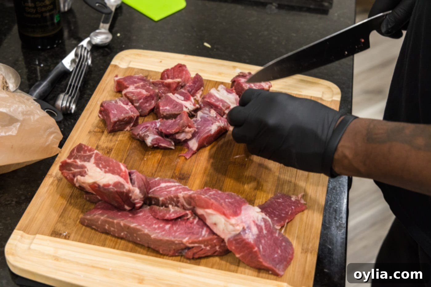 slicing chuck roast into 2-inch cubes for beef tips