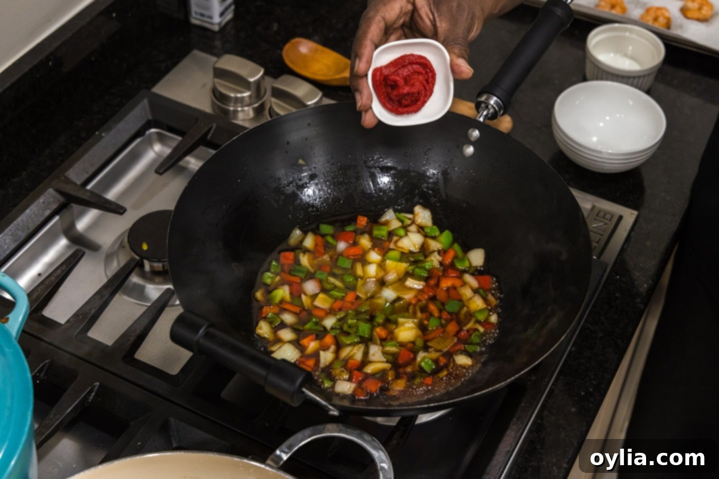 Tomato paste added to the skillet with the sweet and sour sauce base and vegetables.