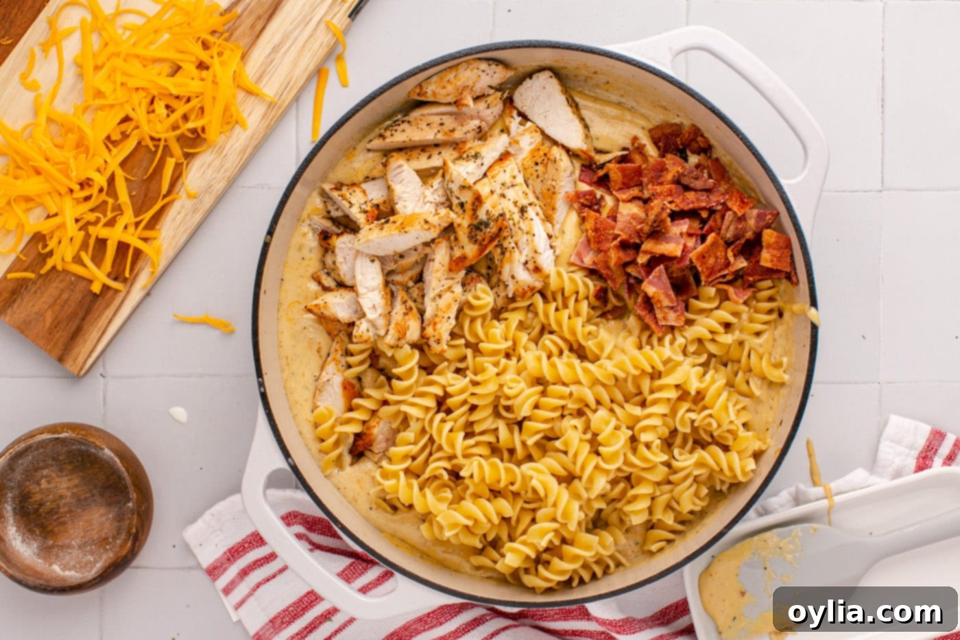bacon, chicken, and pasta added to creamy ranch sauce in a skillet